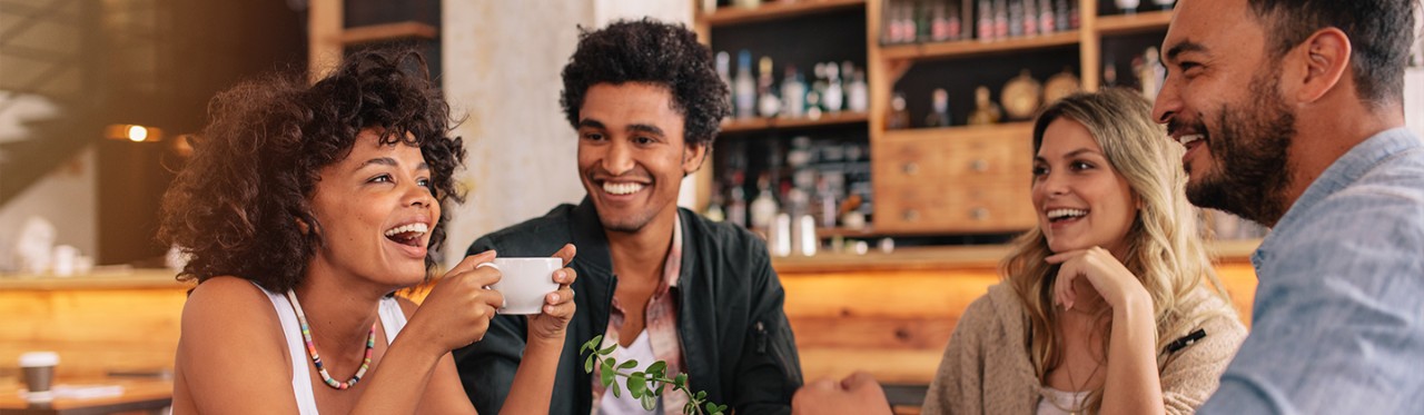 A group of friends laughing and relaxing together at a coffee shop