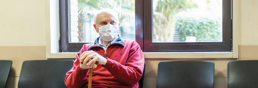 A man sits in an emergency waiting room. 