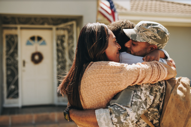 A veteran hugging their family