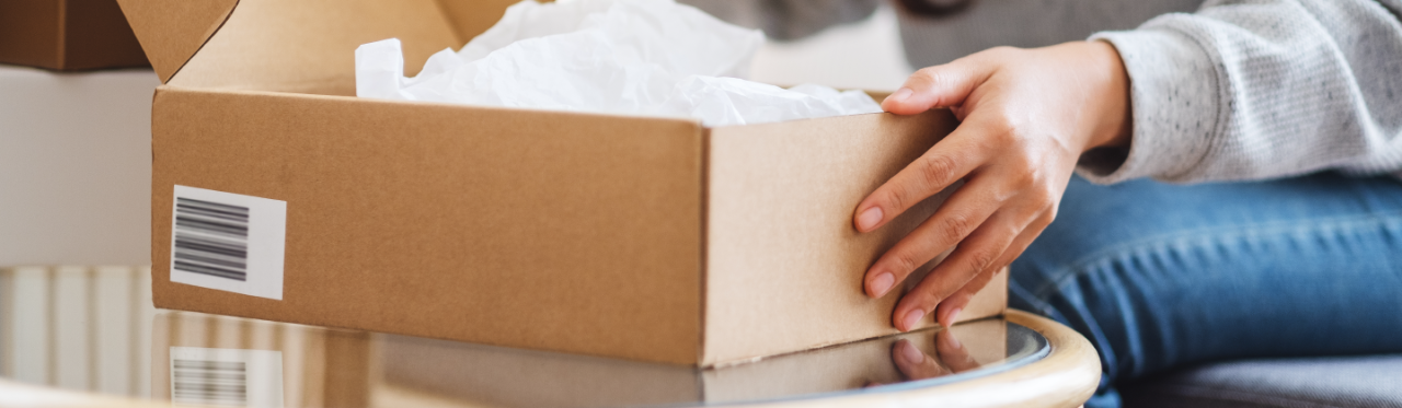 A woman unboxes her at-home microbiome testing kit. 