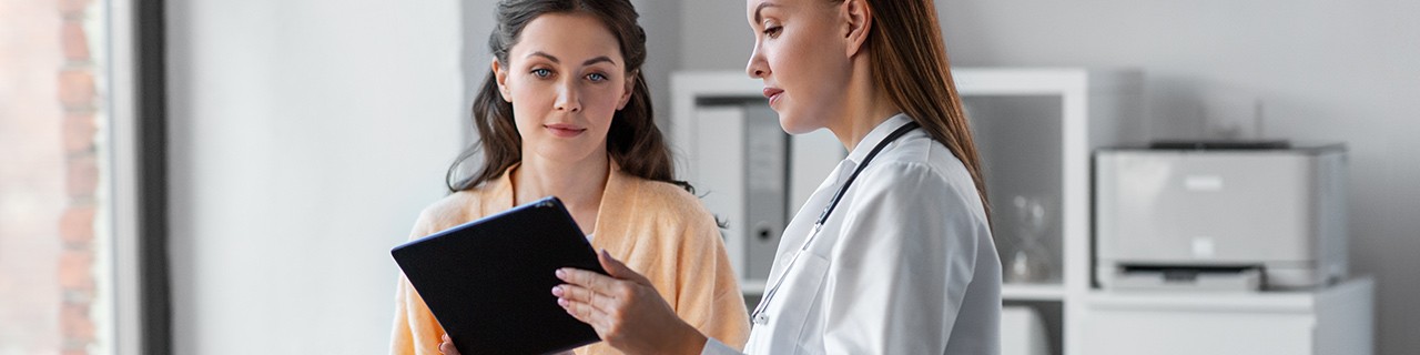 Female patient looking over a clipboard with her physician