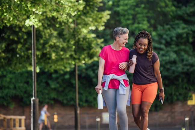 Two women walking along a path outside together