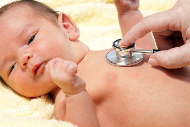 Doctor uses stethoscope to check a baby's heartbeat 
