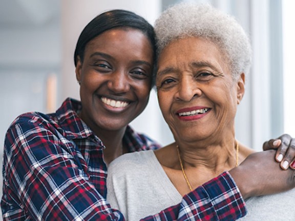 Two happy women smiling and hugging 