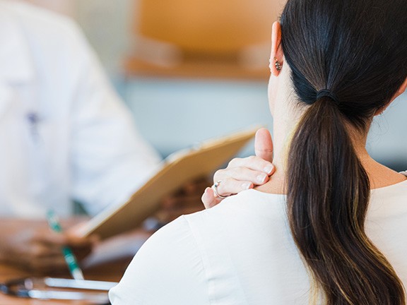 A patient describing where on her neck she's feeling pain.