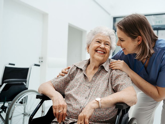 Elderly patient smiling at nurse.