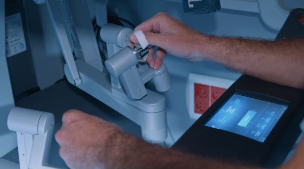 a health care professional working with a robotic surgical machine