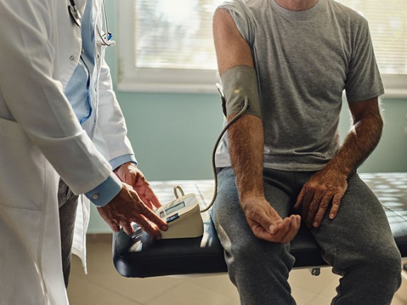 A patient getting their blood pressure levels checked by a healthcare professional. 