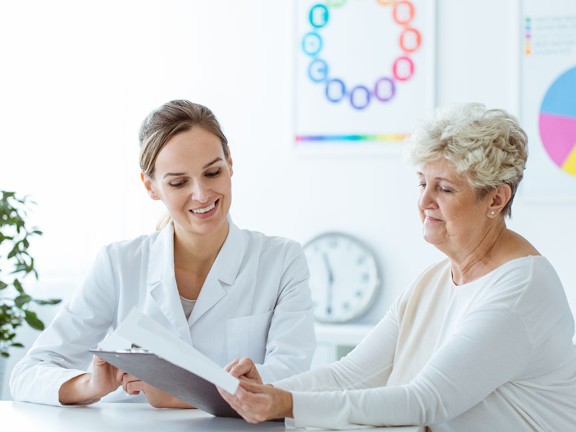 A patient and doctor reviewing paperwork at the doctor's office. 