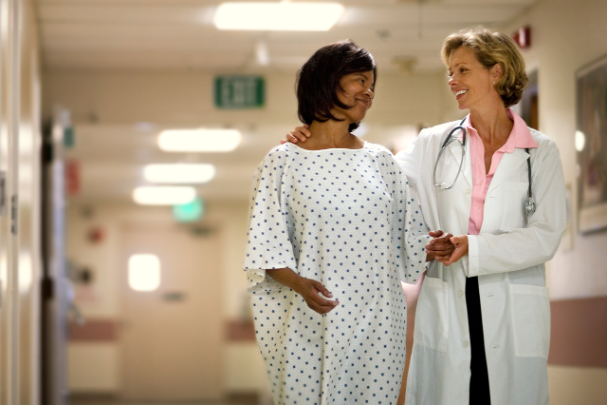 A breast cancer patient happily walks with her doctor. 