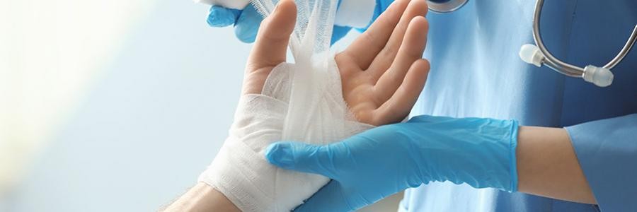 A doctor dresses a patient's hand with burn wound