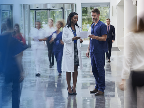 health professionals speaking in a busy hallway