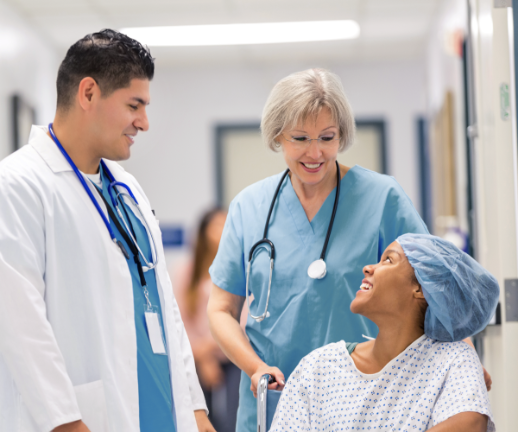 A doctor and a nurse speak with a patient about her procedure before leading her to surgery.