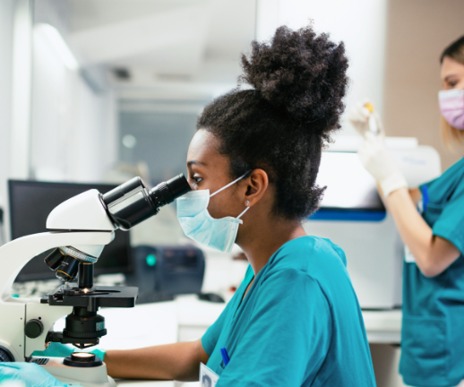 A laboratory technician uses a microscope to review samples from a patient's medical test. 