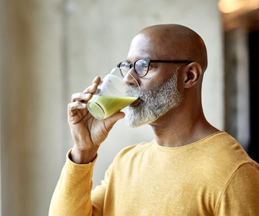 A senior man sips on a green drink to try to improve his kidney health.