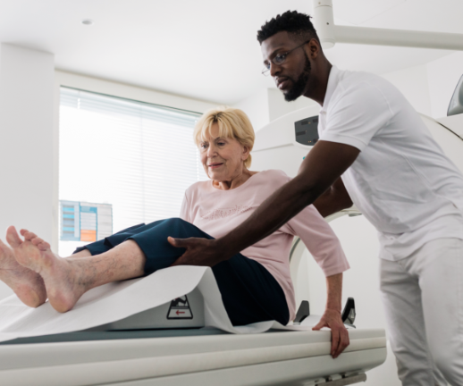 A male nurse helps a patient get into the proper position for her MRI scan.