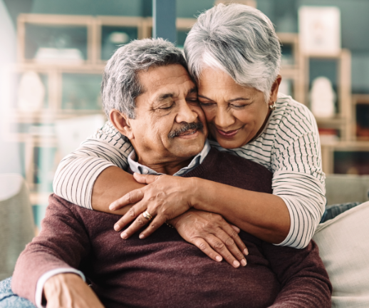 An older woman hugs her spouse in an act of humankindness. 