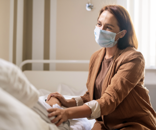 A woman visits her family member in the hospital during visiting hours.