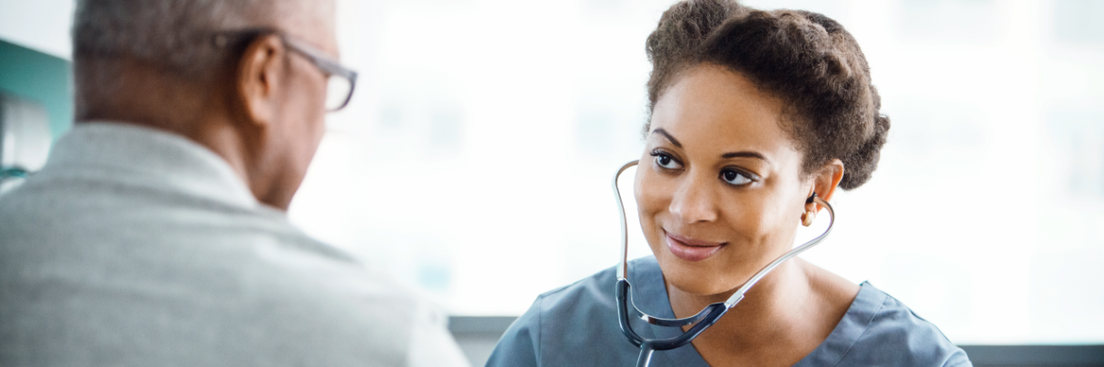 A cardiologist holds a stethoscope to check her patient's heart rate and rhythm.