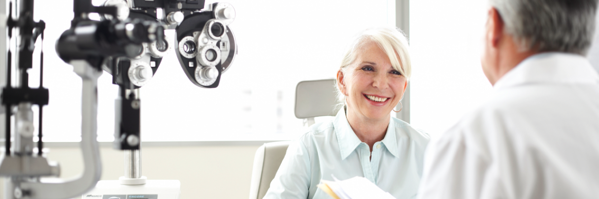 An ophthalmologist talks with his female patient about her eye health.