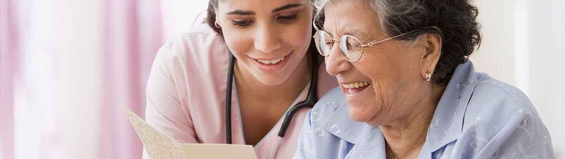 nurse reads card with senior patient