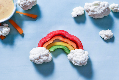 Bell pepper slices and cauliflower florets make a rainbow.