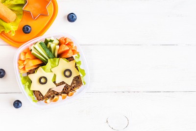 5 Sneaky Ways to Get Your Kids to Eat Their Veggies | St. Luke's Health A sandwich sits in a container with carrot sticks and zucchini.
