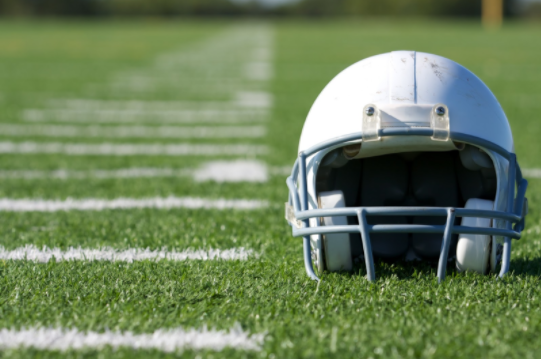 Football helmet sits on a sunny football field
