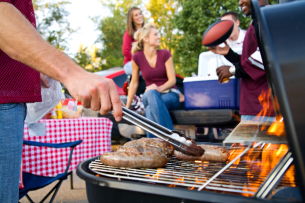 Partygoers grilling and having a good time at a sports tailgate