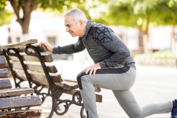 Elderly man stretching to relieve lower back pain 