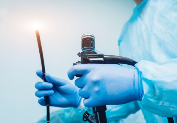 A surgeon holds an endoscope as he operates on a patient. 