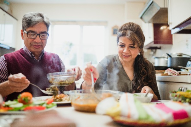 Older couple eating meal at table 