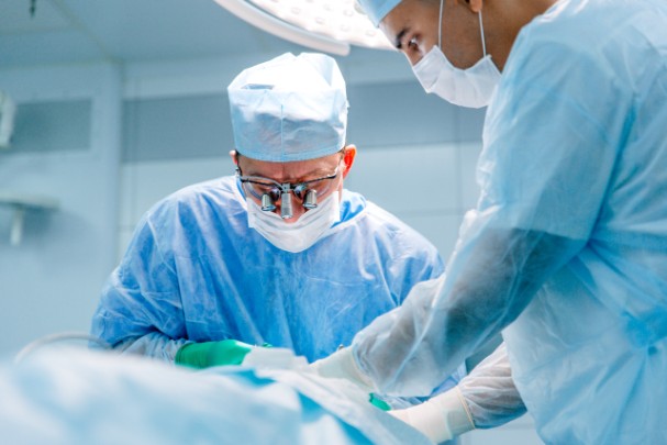 A surgeon operates on a person, removing their cancer. 
