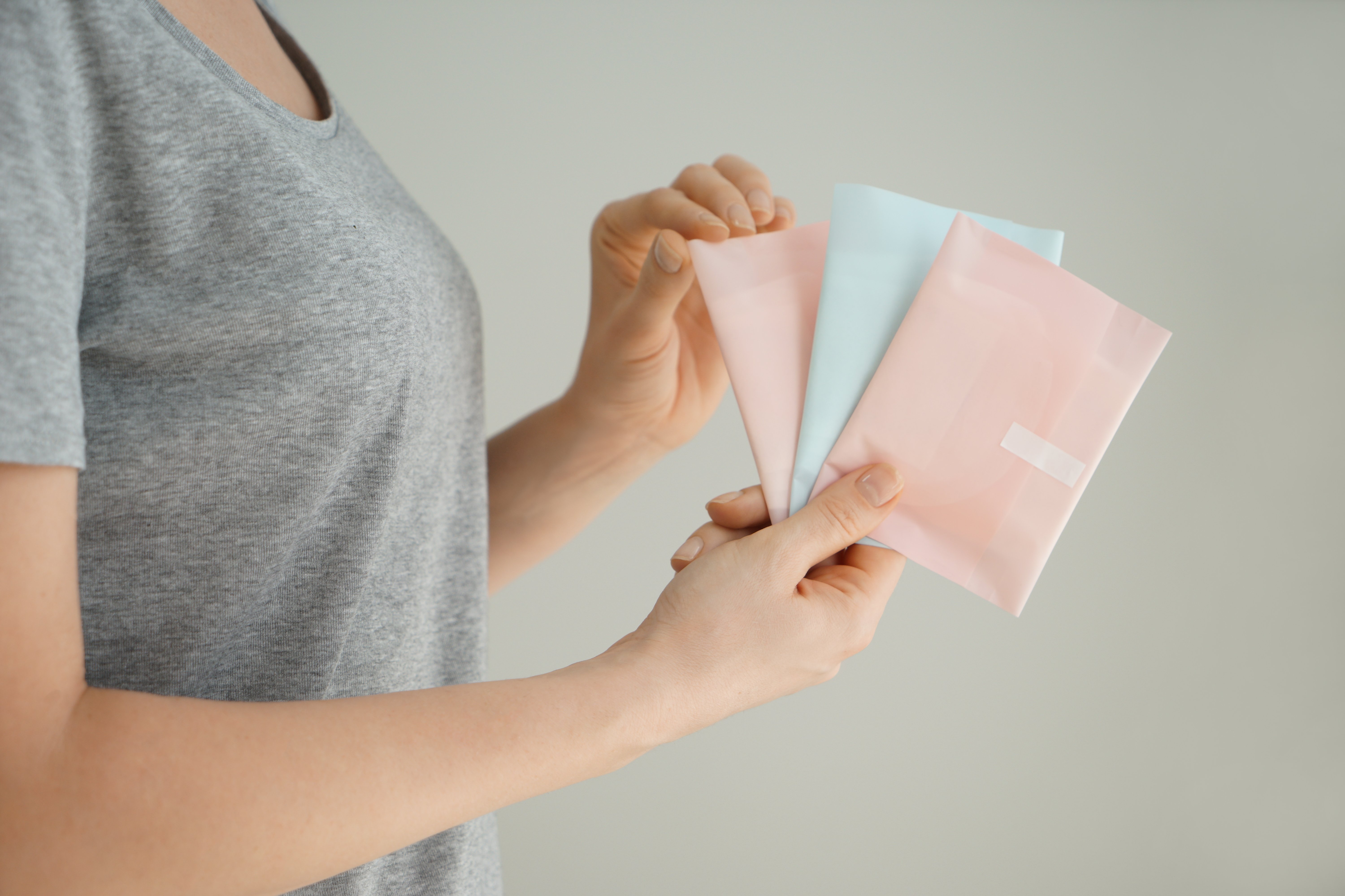 A woman holds multiple menstrual pads 