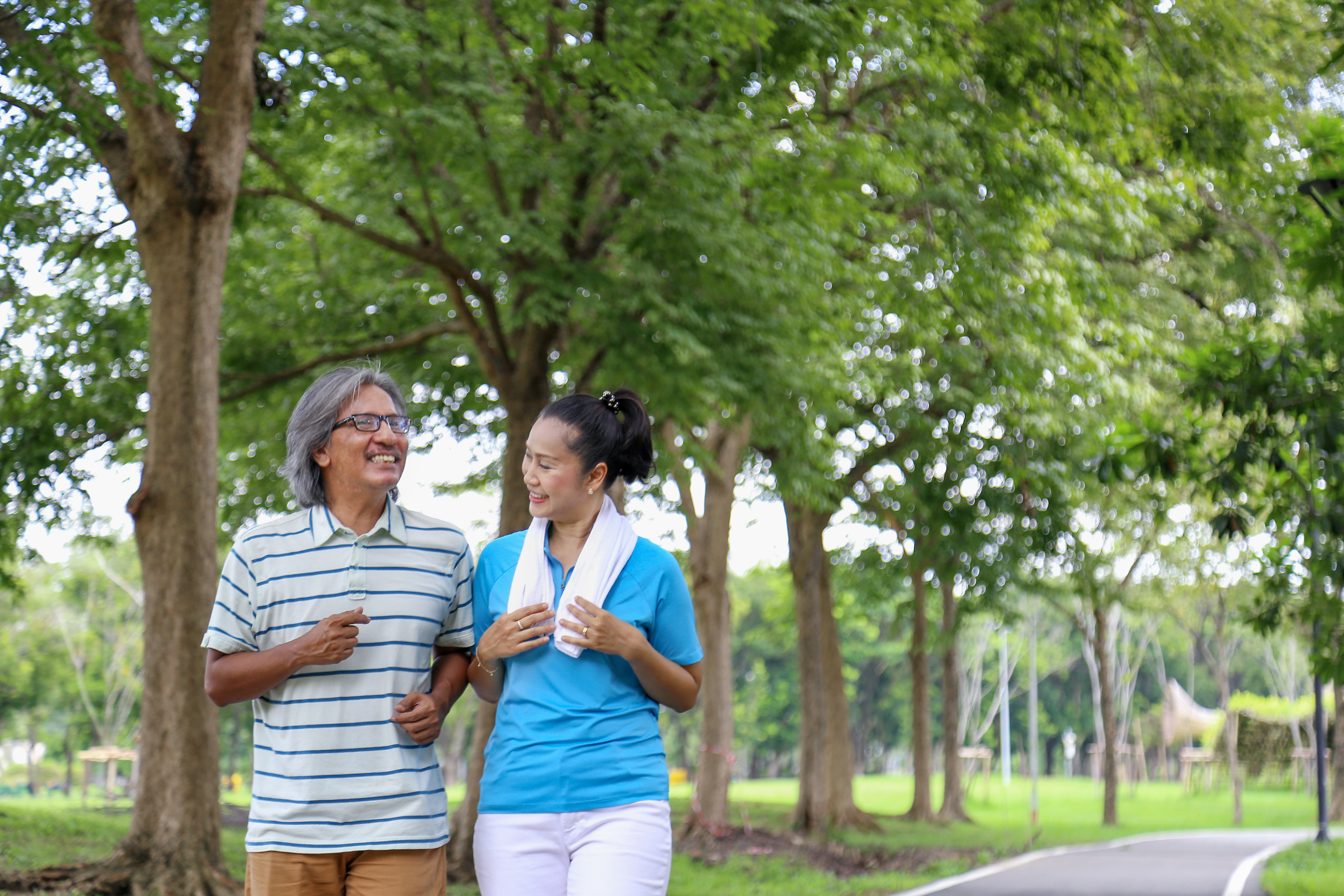 Older couple walking through a park