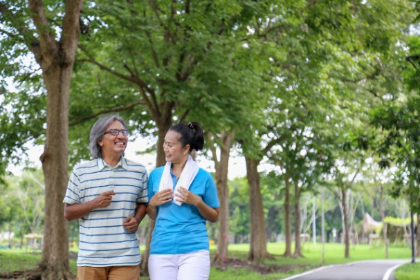 Older couple walking through a park