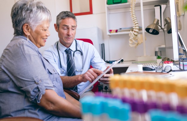 A doctor discusses procedure eligibility with an elderly woman. 