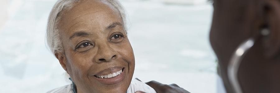 Older woman smiling at middle-aged daughter