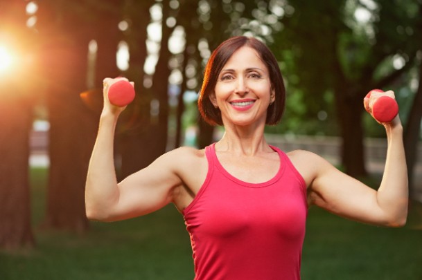 A woman exercises in the middle of a park.