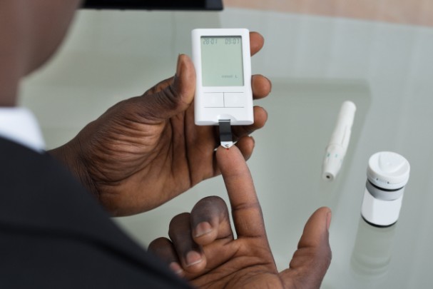Older man tests his blood sugar levels with a monitor 