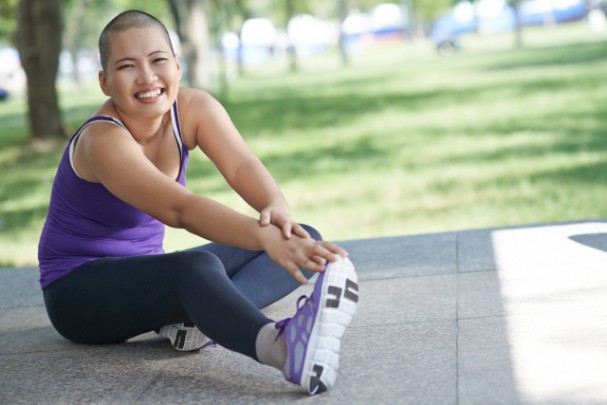 A cancer survivor is stretching her legs in a park