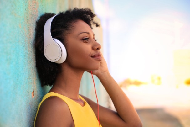 A young woman listens to music through headphones. 