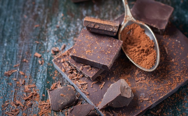 Dark chocolate bar and a spoon full of cocoa powder 