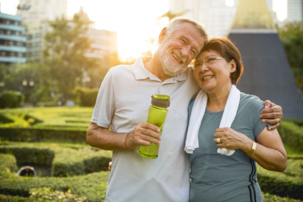 An elderly couple embrace after exercising 