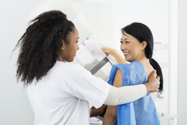 What You Need to Know Before Getting a Mammogram | St. Luke's Health A mammography tech helps a woman get ready for her mammogram.