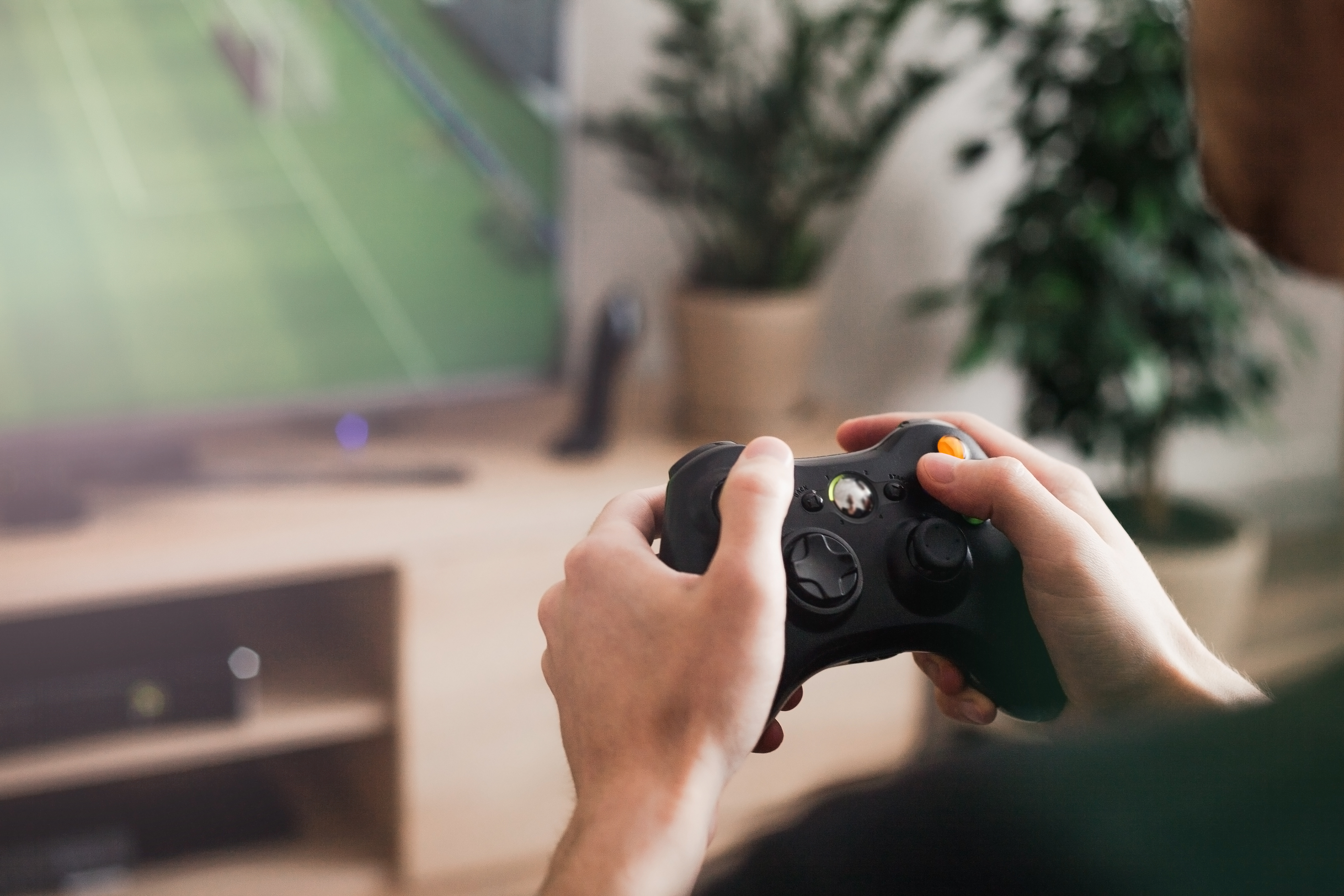 A person plays a sports video game and holds the controller 