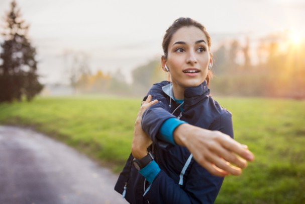 A woman stretches outside before her winter workout. 