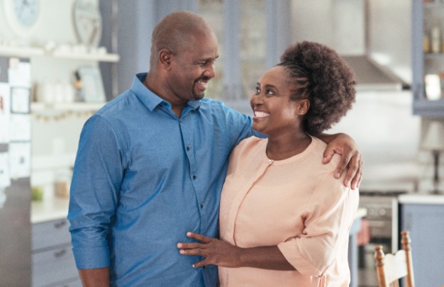 A couple embrace lovingly in their kitchen 