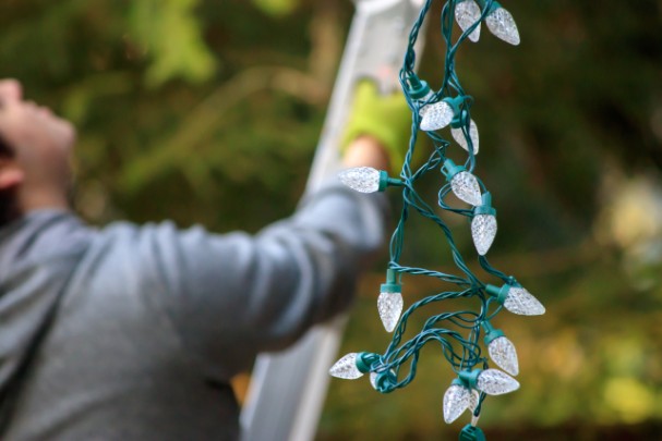 A man prepares to hang up Christmas lights.