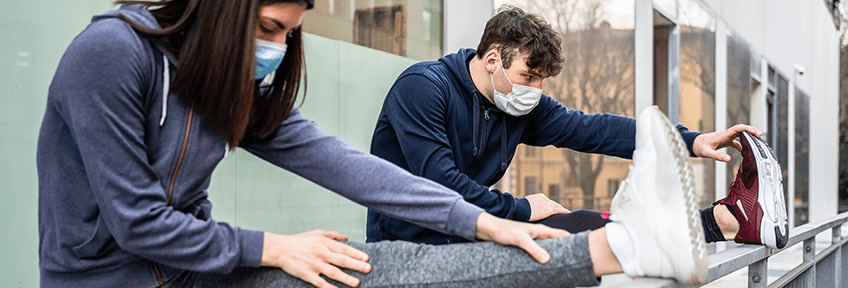 Young couple prepares to ease back into exercise after a long break by stretching.